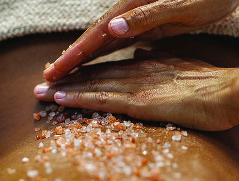 hands massaging body salts into skin
