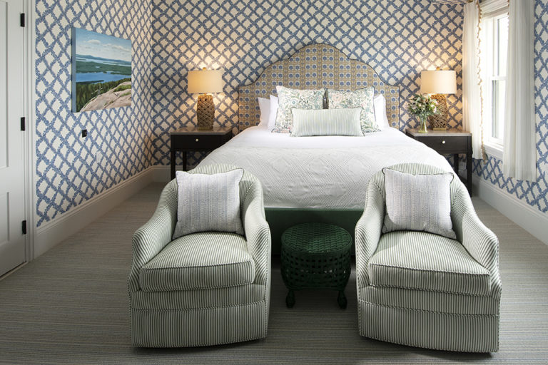 Summer house room with blue wallpaper, bed and chairs