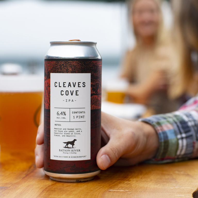 Cleaves Cove beer can being held on table.